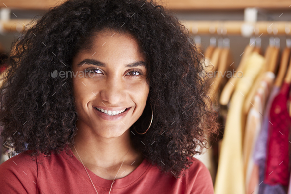 Portrait Of Female Customer Or Owner Standing By Racks Of Clothes In Independent Fashion Store