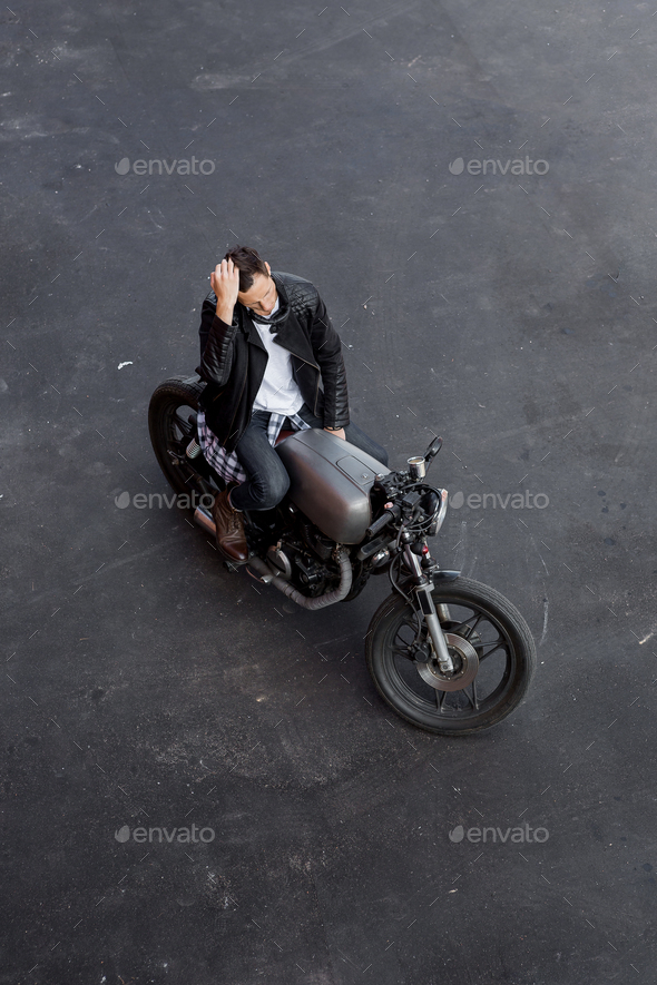 Top view to brutal man with cafe racer custom motorbike.