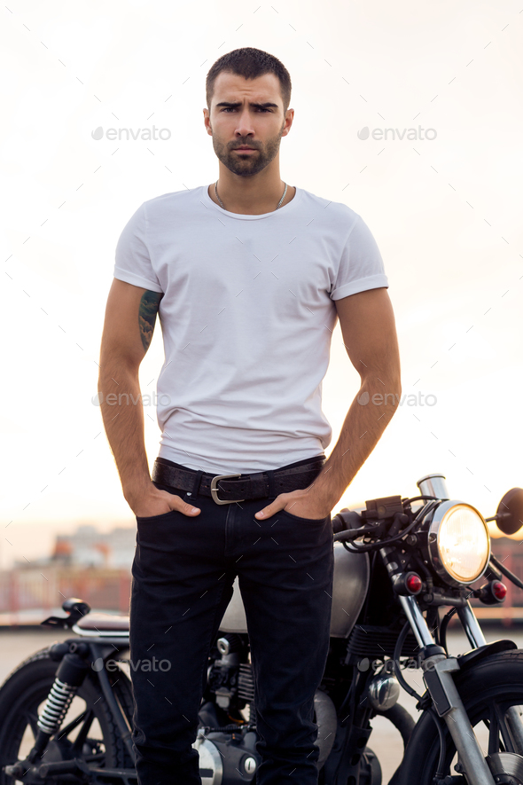 Brutal man near his cafe racer custom motorbike. - Stock Photo - Images