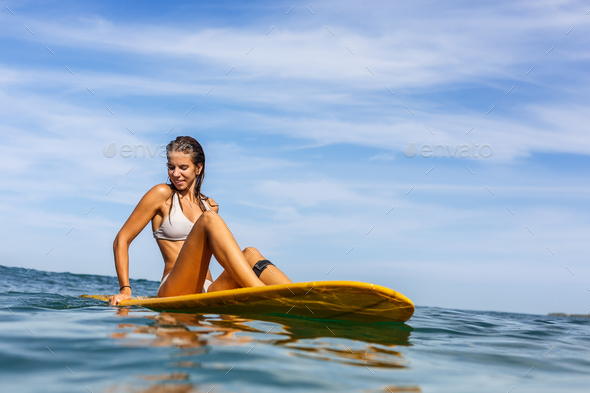 One beautiful sporty girl surfing in the ocean. - Stock Photo - Images