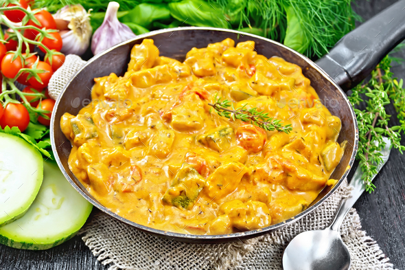 Goulash with tomato and zucchini in pan on burlap - Stock Photo - Images