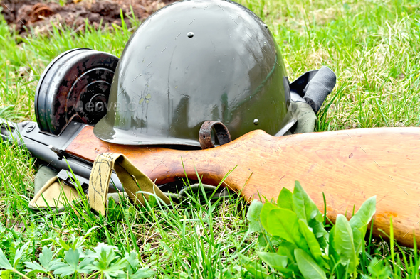 Helmet and submachine gun on grass - Stock Photo - Images