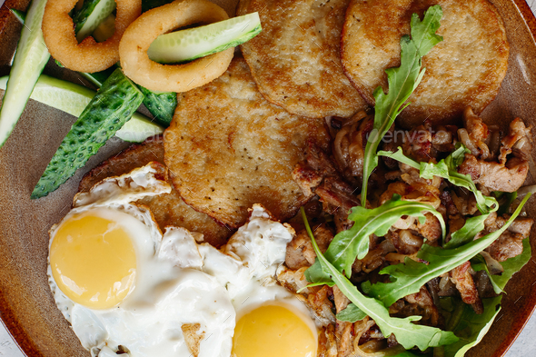Delicious potato puncakes lying on brown clay plate - Stock Photo - Images