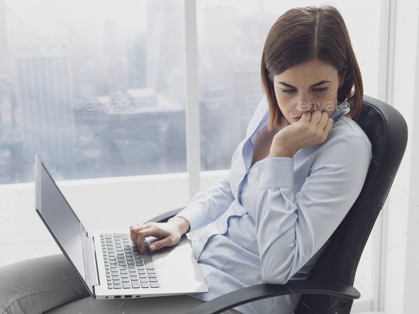 Pensive businesswoman working with her laptop - Stock Photo - Images