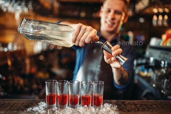 Male barman in apron prepares alcoholic coctail - Stock Photo - Images
