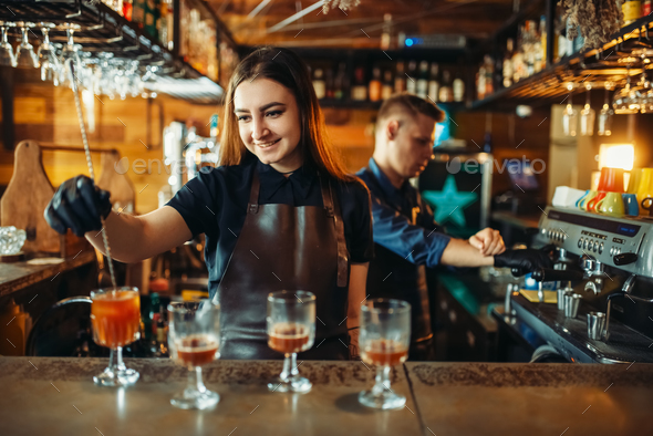 Male and female bartender at the bar counter - Stock Photo - Images