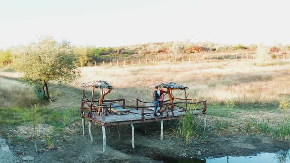 Inlove Couple Spending a Romantic Evening on a Pontoon in a Rural Area alt
