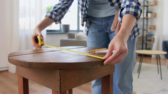 Woman with Ruler Measuring Table for Renovation alt