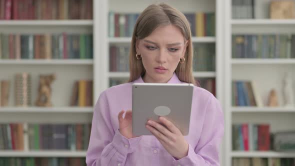 Portrait of Woman Celebrating on Tablet in Office alt