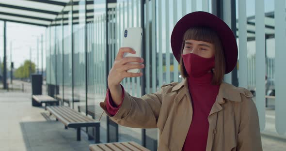 Young Woman in Cotton Mask Taking Selfies Near Modern Glass Building, Attractive Millennial Girl alt