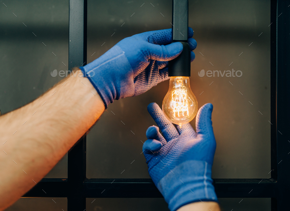 Electrician changes the light bulb, handyman - Stock Photo - Images