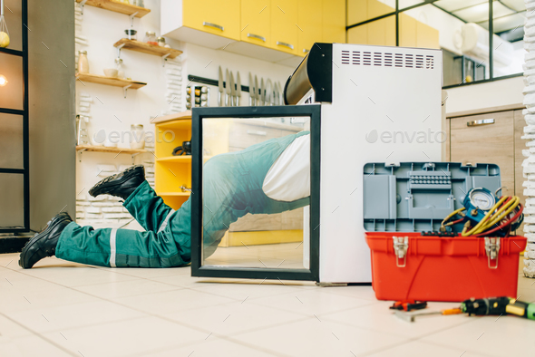 Worker in uniform climbed inside the refrigerator - Stock Photo - Images