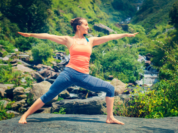 Woman doing Ashtanga Vinyasa Yoga Virabhadrasana 2 Warrior pose - Stock Photo - Images