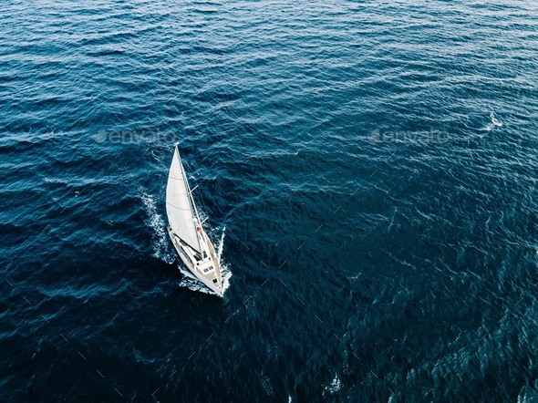 Aerial view of Sailing ship yachts with white sails  in deep blue sea - Stock Photo - Images