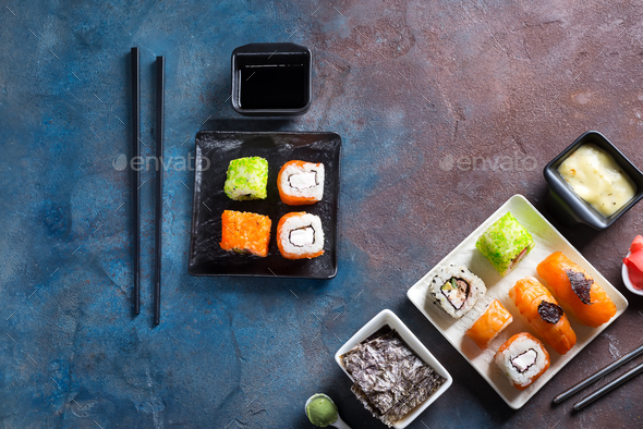 Traditional Japanese food- sushi, rolls, chopsticks, soy sauce on color stone background. Sushi menu