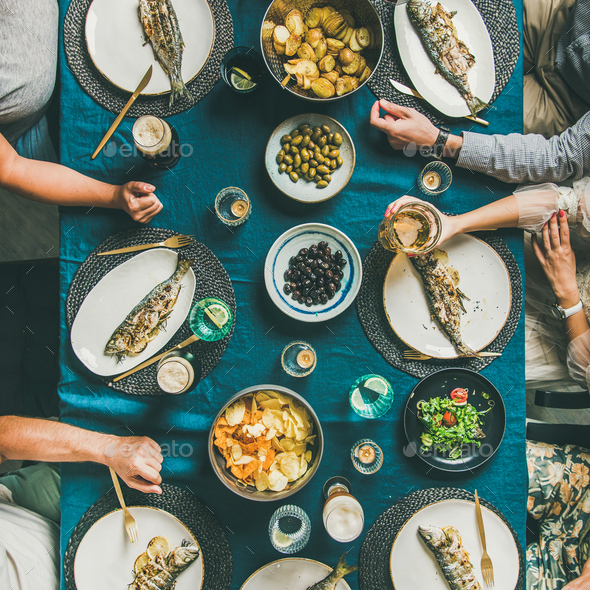 Flat-lay of people eating fish and drinking beer, square crop - Stock Photo - Images