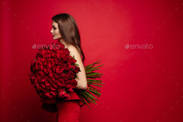 Gorgeous woman in red dress keeping bouquet of roses - Stock Photo - Images