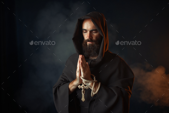 Medieval monk praying with closed eyes - Stock Photo - Images
