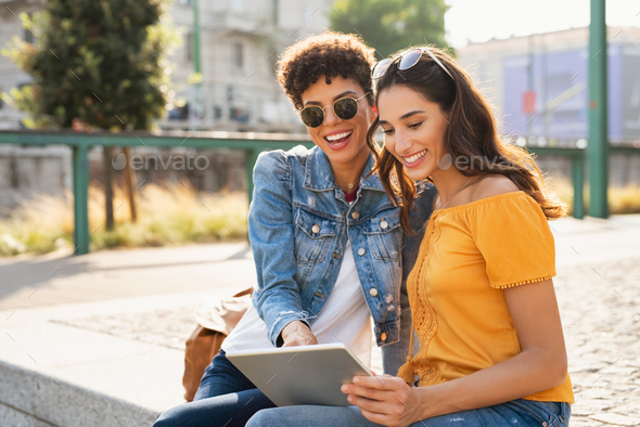 Two women using digital tablet outdoor - Stock Photo - Images