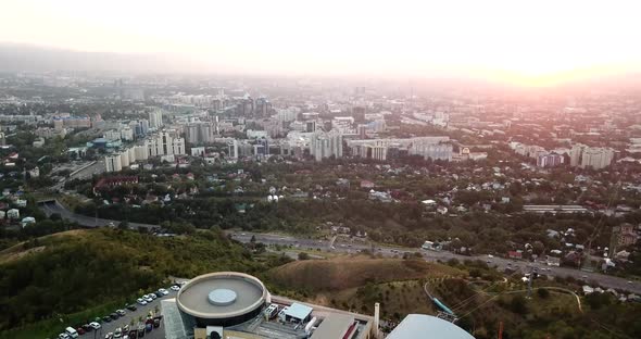 Ferris wheel at sunset overlooking the city and mountains. Almaty, Kazakhstan. alt