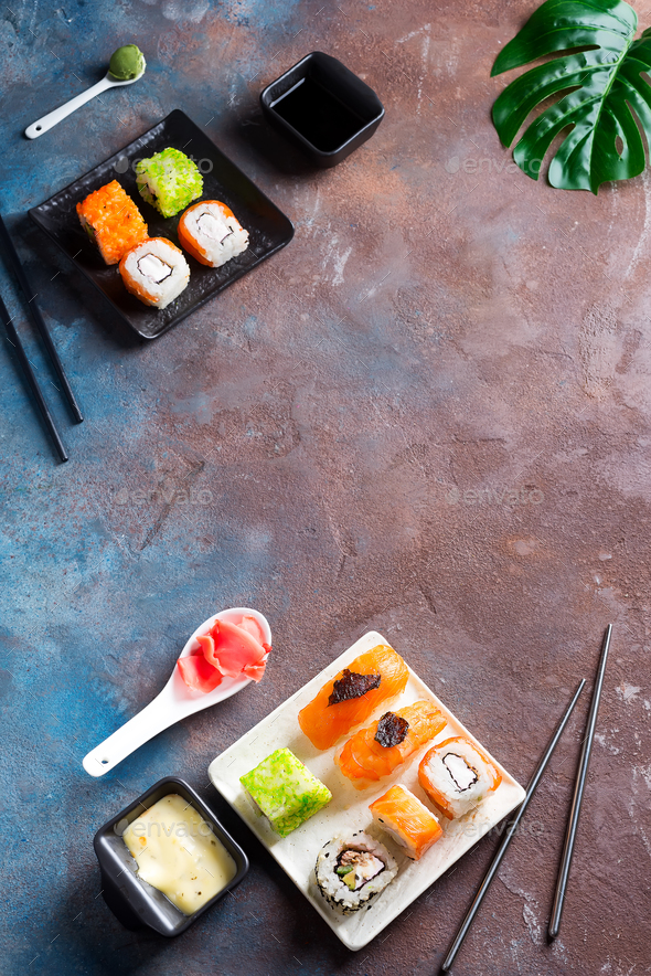 Various Fresh and delicious sushi set on black slate with slate sticks, sauce and nori on duotone - Stock Photo - Images