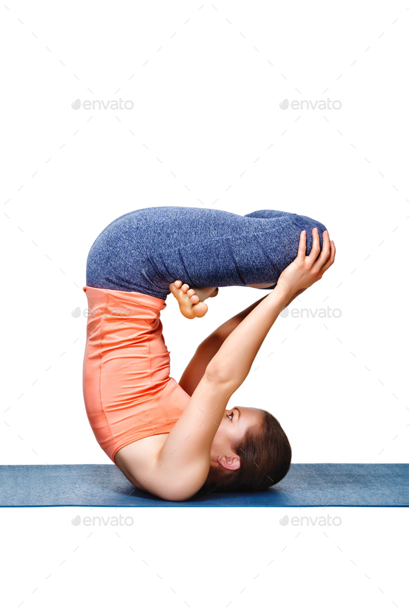 Sporty fit yogini woman practices inverted yoga asana