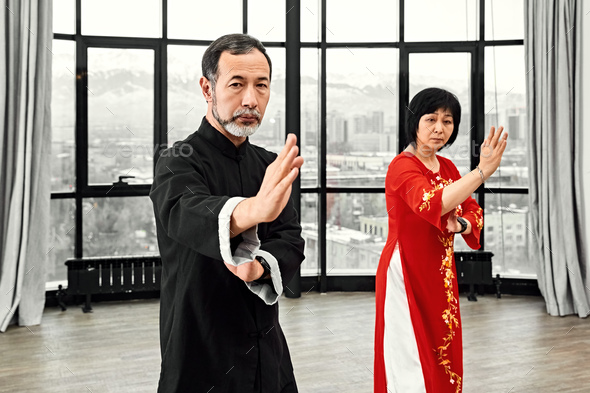 Couple of senior masters practicing qi qong taijiquan - Stock Photo - Images