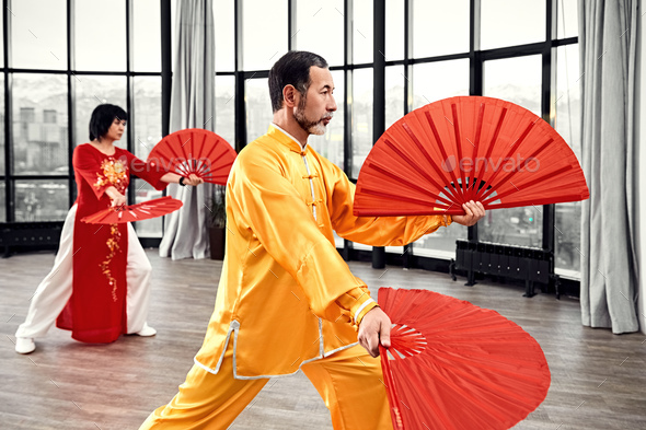 Couple of senior masters practicing qi qong taijiquan - Stock Photo - Images