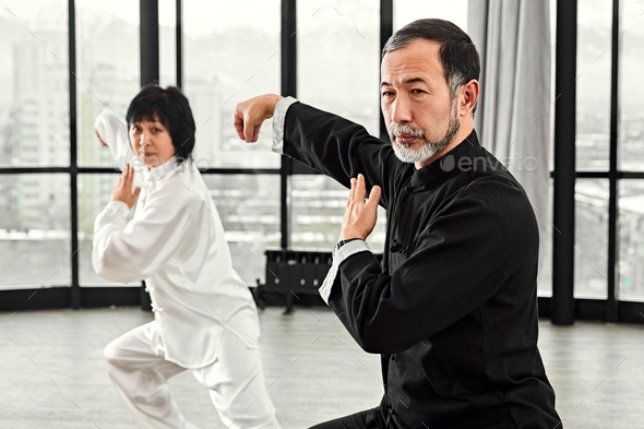 Couple of senior masters practicing qi qong taijiquan - Stock Photo - Images