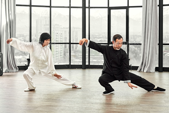 Couple of senior masters practicing qi qong taijiquan - Stock Photo - Images