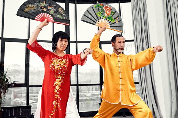 Couple of senior masters practicing qi qong taijiquan - Stock Photo - Images