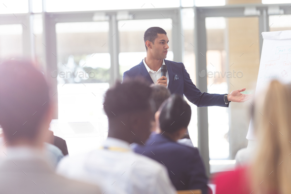 Front view of handsome mixed-race businessman speaking in business seminar at conference - Stock Photo - Images
