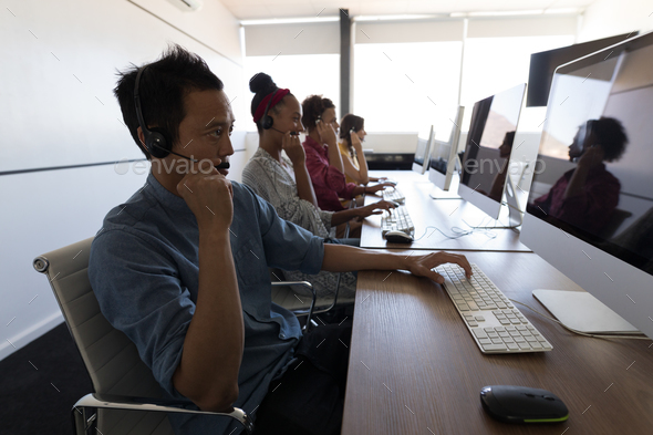 Executives talking on headset in modern office