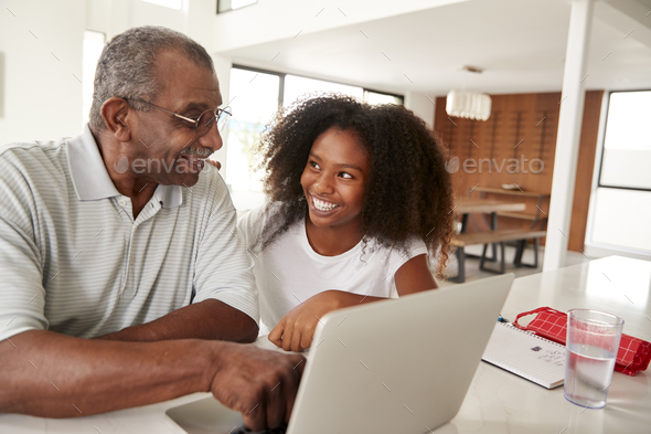 Teenage Black Girl Helping Her Grandfather Use A Laptop Computer Smiling At Each Other Close Up Stock Photo By Monkeybusiness