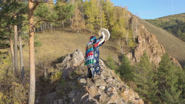 Aerial Shot of a Mysterious Magical Ritual of a Mountain Shaman Standing on Top of a Rock.