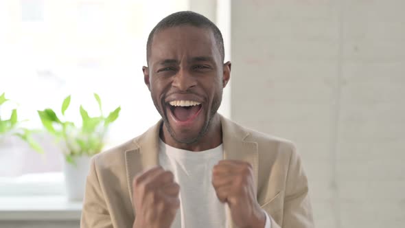 Portrait of Excited African Man Celebrating Success alt
