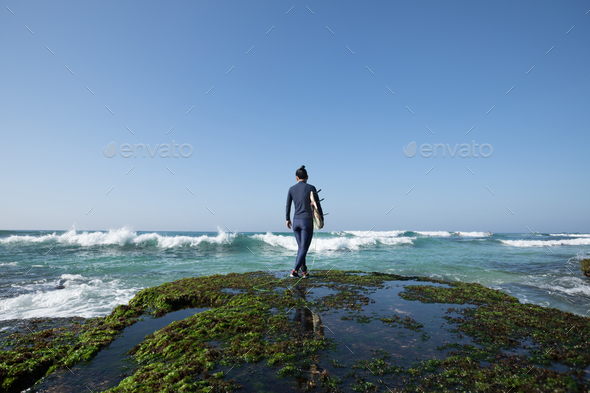 Surfer with surfboard on seaside - Stock Photo - Images