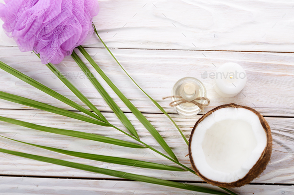 Flat lay Coconut oil in glass bottle bath sponge candle and shel - Stock Photo - Images