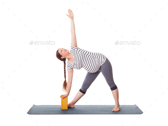 Pregnant woman doing yoga asana Utthita trikonasana - Stock Photo - Images