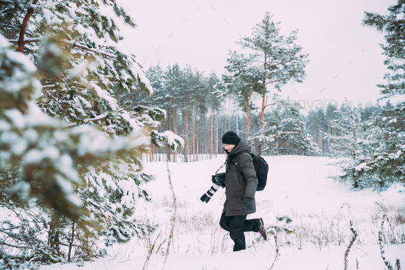 Young Man Backpacker With Photo Camera Taking Photo In Winter Sn - Stock Photo - Images