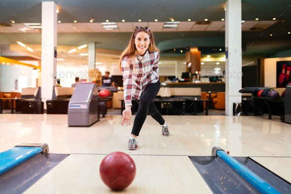 Focused happy woman enjoying bowling