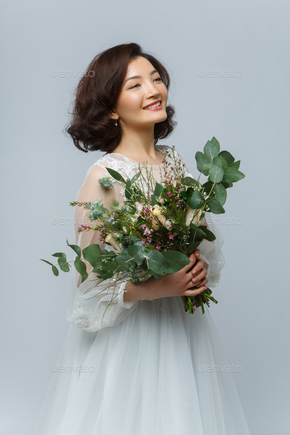 beautiful girl in white dress with big bouquet - Stock Photo - Images