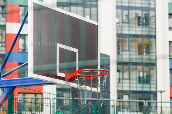 Basketball ring on a closed court in the courtyard of a multi-storey building. - Stock Photo - Images