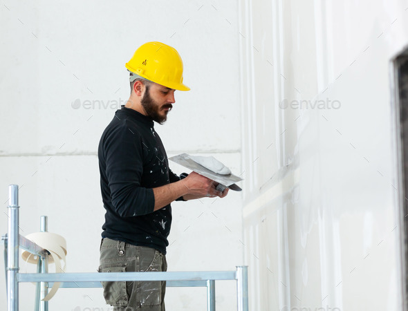 worker plastering gypsum board wall. Stock Photo by AntonioGravante