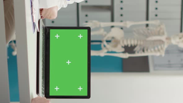 Vertical Video General Practitioner Showing Laptop with Greenscreen to Retired Patient alt