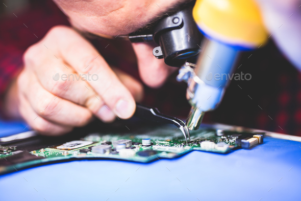 IT worker fixing main board of a computer.