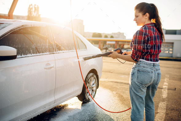 Female person wash off the foam from car - Stock Photo - Images