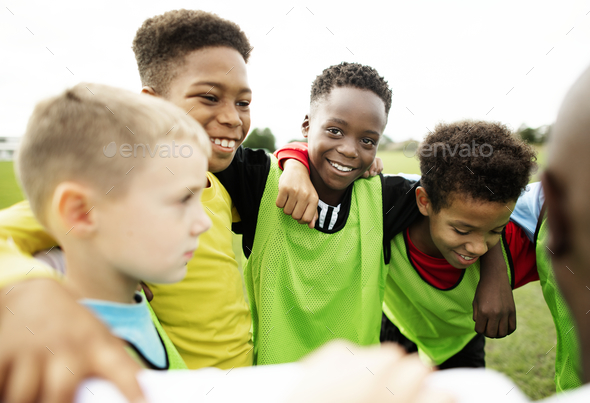 Junior football team huddling together