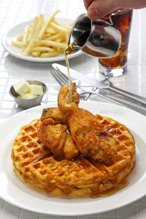 fried chicken and waffles with maple syrup, american food Stock Photo by motghnit
