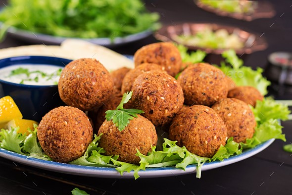 Falafel, hummus and pita. Middle eastern or arabic dishes on a dark background. Halal food.